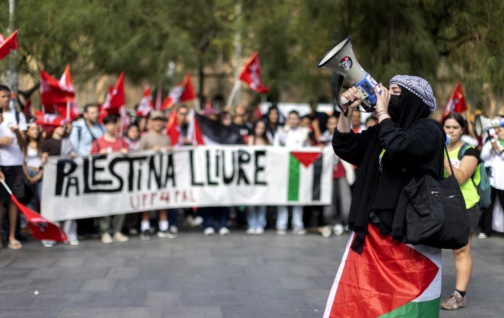 Una mujer, con un pañuelo palestino y un megáfono, grita consignas durante la protesta en Barcelona, el 2 de octubre de 2025. Foto: EFE