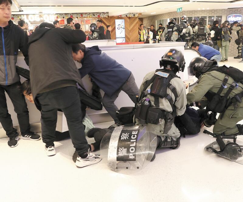 Agentes antidisturbio detienen a un manifestante en un centro comercial, en Sha Tin, Hong Kong. LUCY NICHOLSON. REUTERS