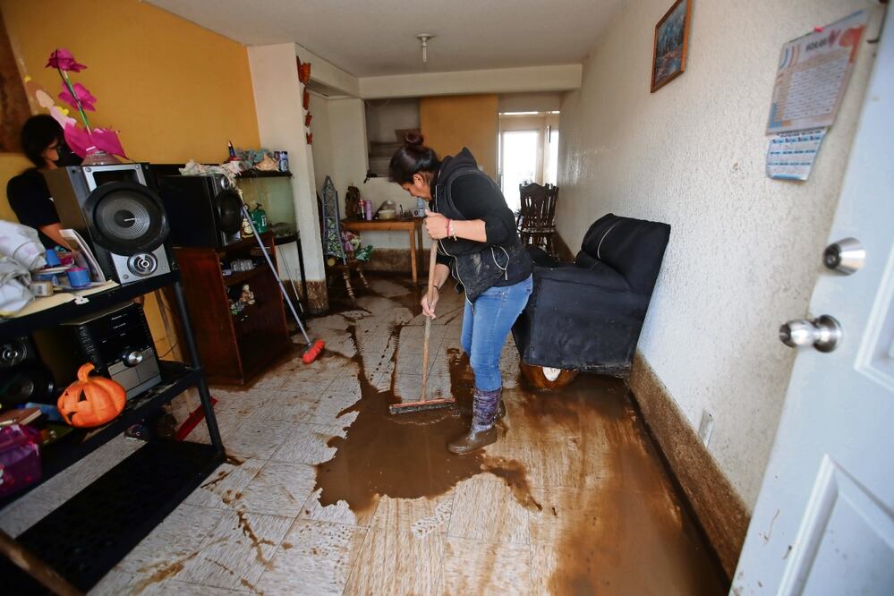 Vecinos de Los Héroes Segunda Sección limpiaban sus viviendas y trataban de rescatar muebles tras la inundación de aguas negras. Foto: Francisco Rodriguez / EL UNIVERSAL