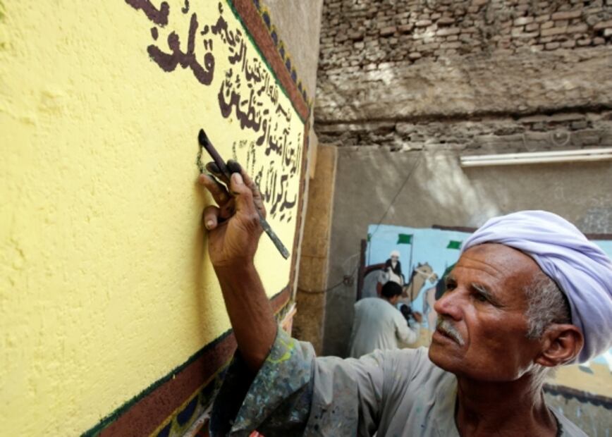 Artista pinta murales en casas para celebrar el haj