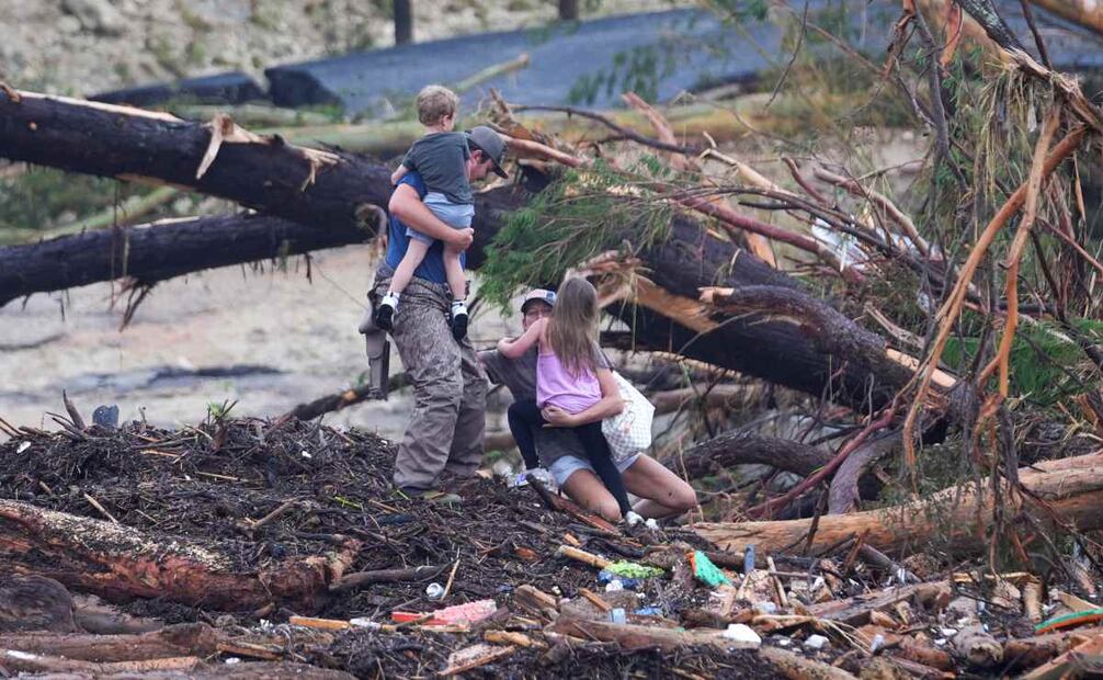 Una mujer se cae mientras camina entre escombros en un puente sobre el río Guadalupe luego de que una inundación repentina azotó la zona, el sábado 5 de julio de 2025, en Ingram, Texas. Foto: AP