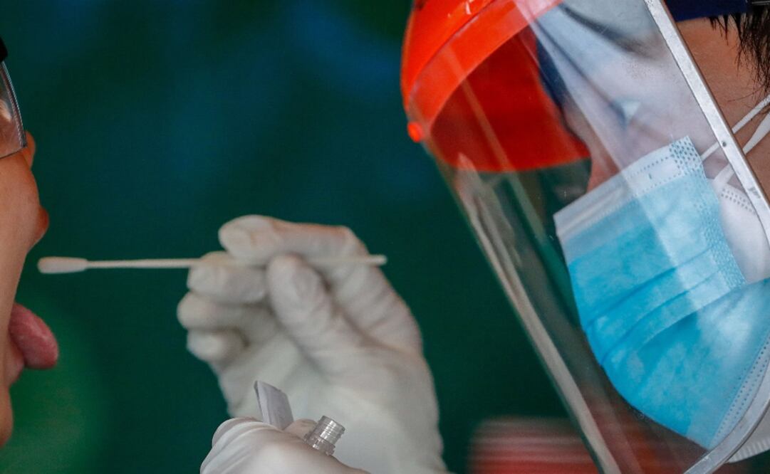 A health worker performs a swab test to a woman - Photo: Mark R. Cristino/EFE