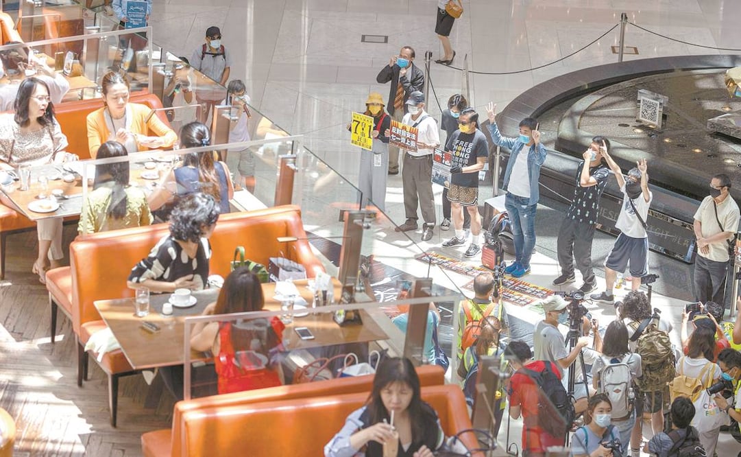 Manifestantes prodemocracia protestan en un centro comercial de Hong Kong contra la ley de seguridad que ayer aprobó el Parlamento chino. Foto: JEROME FAVRE. EFE