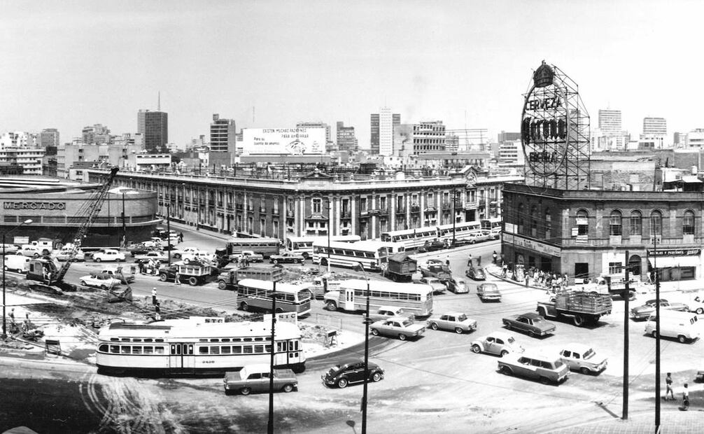 El cruce de las avenidas Bucareli y Chapultepec en 1967, poco después de que iniciaran las obras de la línea 1 del Metro. En el centro está el conjunto habitacional de la cigarrera El Buen Tono, conocido como el Edificio Mascota, y la izquierda se encuentra el Mercado Juárez. Colección Villasana.