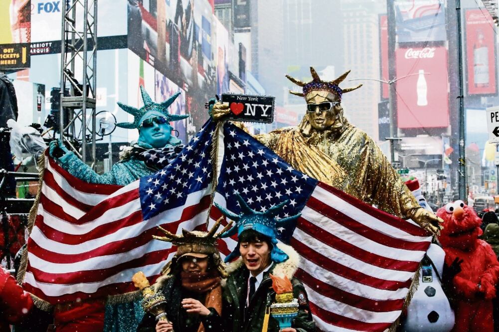 Personas disfrazadas de Estatuas de la Libertad posan para la foto en Times Square, en vísperas de la celebración del Año Nuevo en Manhattan, Nueva York. (EDUARDO MUÑOZ. REUTERS)