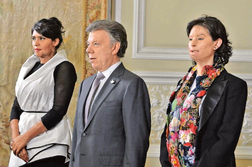 El presidente colombiano, Juan Manuel Santos, en conferencia ayer con dos mujeres que han sido víctimas de ataques con ácido, en la Casa de Nariño, Bogotá (XINHUA)