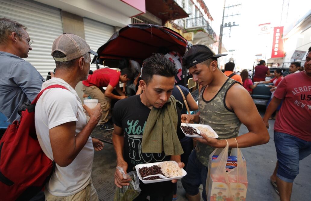 Migrantes hondureños reciben comida de ciudadanos mexicanos durante su travesía hacia Estados Unidos en Huixtla, Chiapas. Foto: EFE