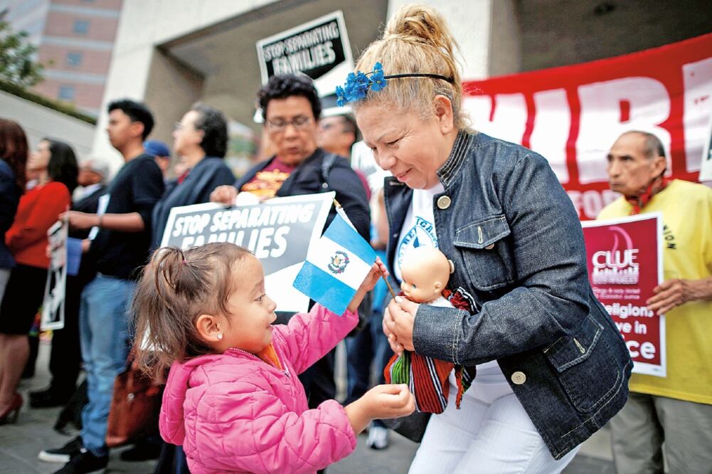 Alice Rodas, cuyo papá está en un centro de detención en N. Jersey, sostiene una bandera de Guatemala, durante una protesta ayer en Los Ángeles (LUCY NICHOLSON. REUTERS)