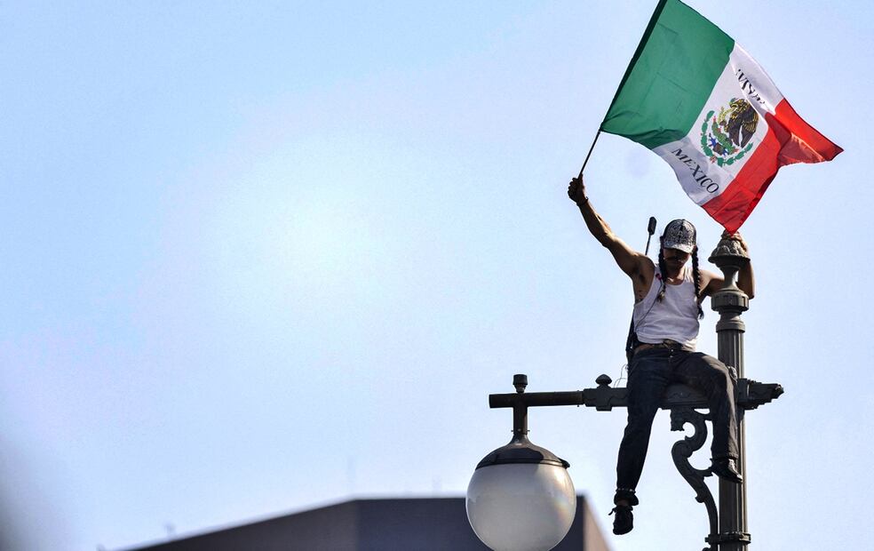 Un manifestante ondea una bandera mexicana en lo alto de un poste de luz frente al Edificio Federal Robert Young en el centro de Los Ángeles, California, el 9 de junio de 2025. Foto: AFP