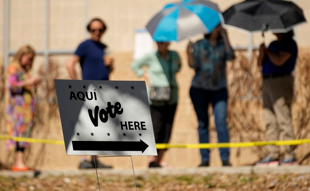 Votantes usan sombrillas para cubrirse del sol mientras esperan formados en un centro de votación, el martes 5 de marzo de 2024, en San Antonio.Foto: AP