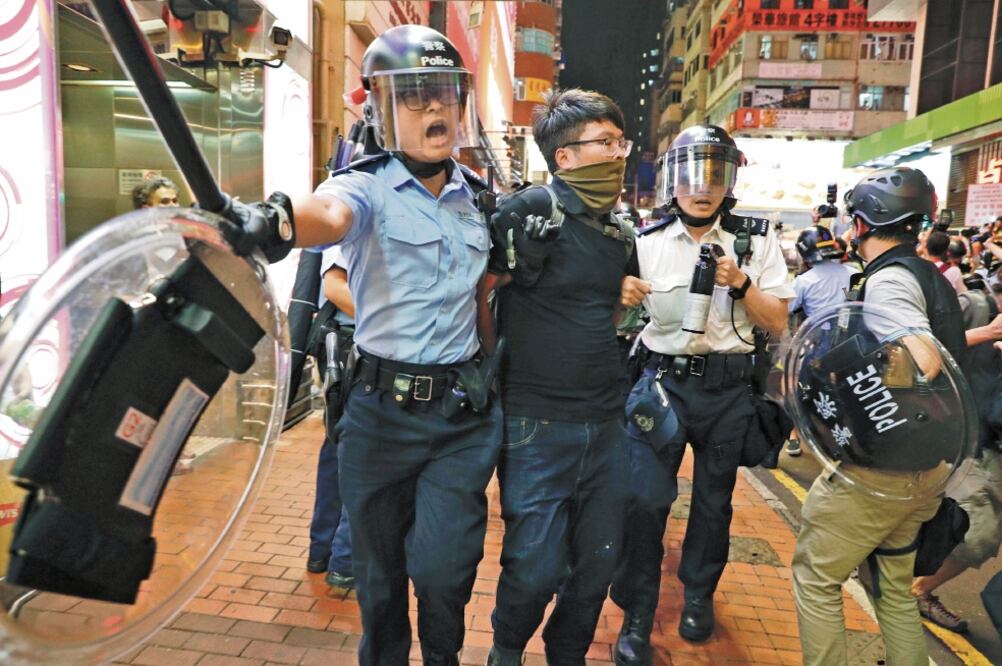 Dos oficiales de la policía de Hong Kong se enfrentaron contra los manifestantes en el barrio de Mongkok, en el norte de la ciudad. Foto/VINCENT YU. AP