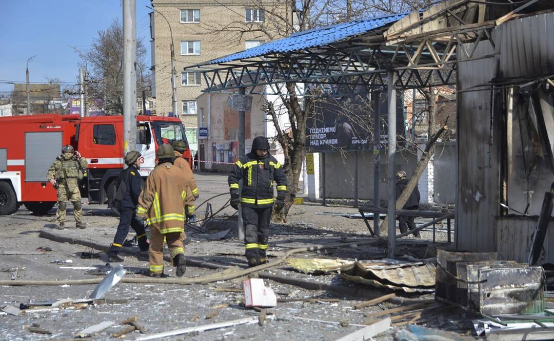 Rescatistas trabajan en una parada de autobús que fue alcanzada durante un ataque con cohetes en Kherson que resultó en la muerte de al menos tres personas. FOTO: EFE