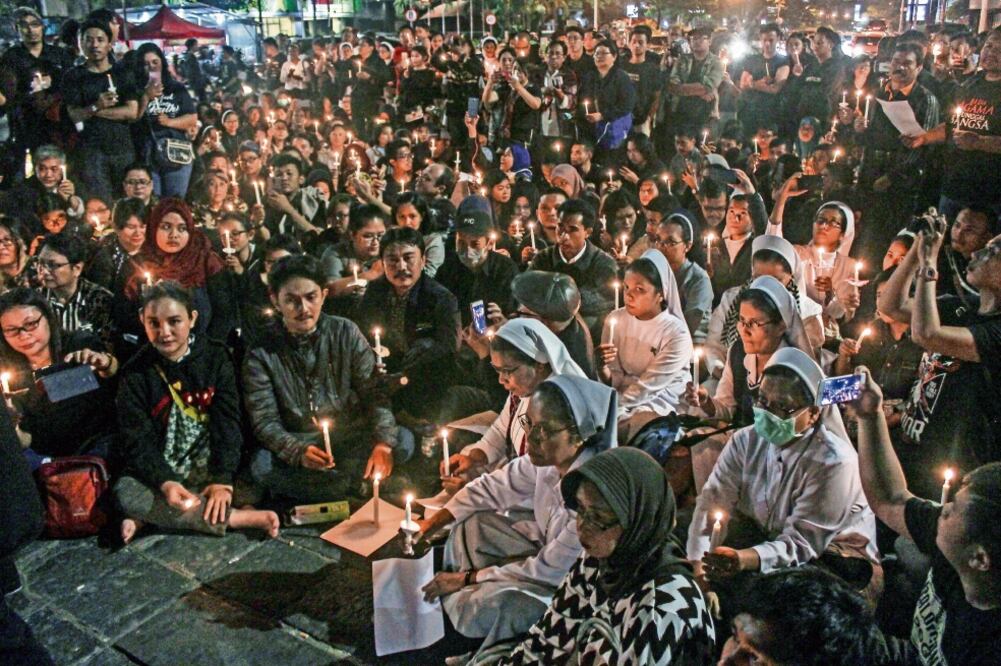 Indonesios realizaron en la noche una vigilia, tras los atentados que también dejaron al menos 40 heridos, en Surabaya. Foto: SLAMET RIYADI. AP
