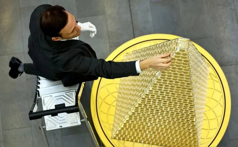 El portavoz de la casa de oro de Múnich, Benjamin Summa, recoge una moneda del árbol de oro. Fuente: EFE