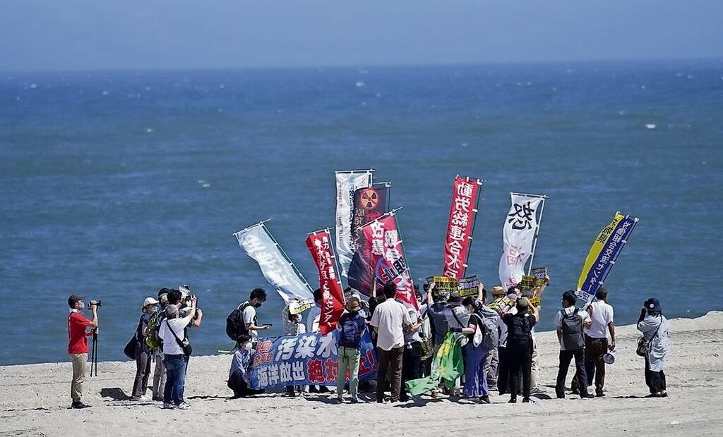 La gente protesta en una playa hacia la planta de energía nuclear de Fukushima Daiichi, dañada por un enorme terremoto y tsunami. Foto: AP