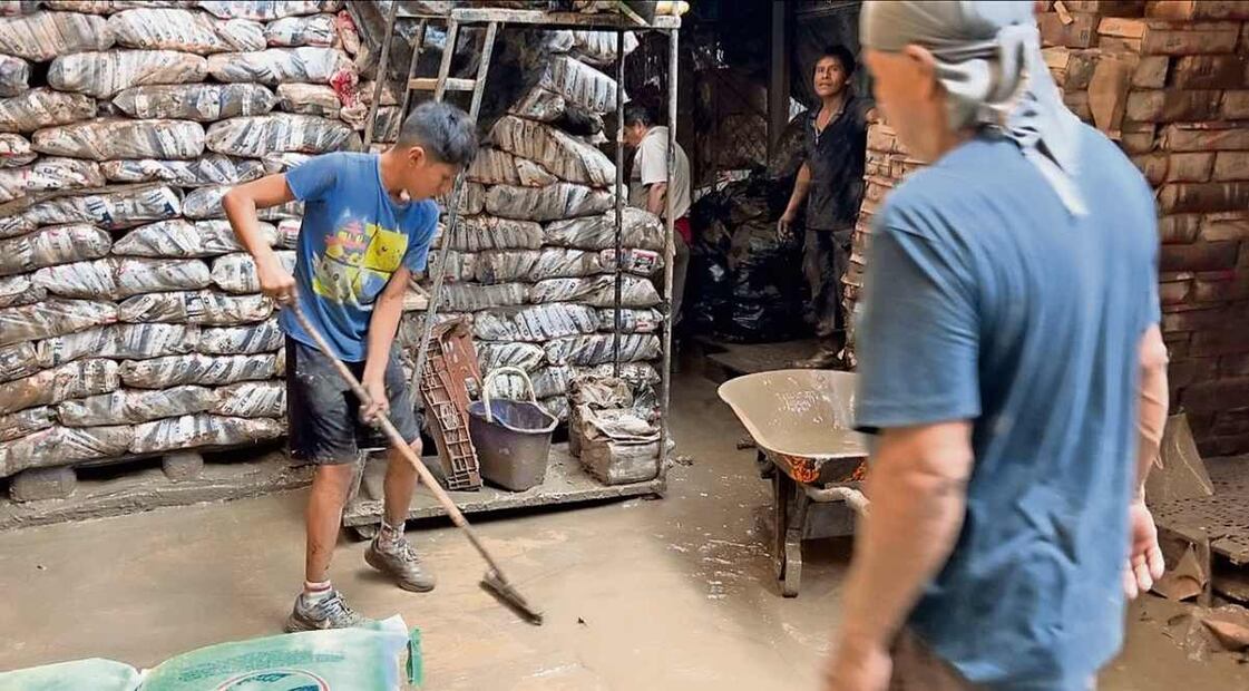 Trabajadores se dedican a las labores de limpieza de las bodegas y a ver qué mercancías se pudieron salvar del agua y el lodo. Foto: Alelhí Salgado / EL UNIVERSAL