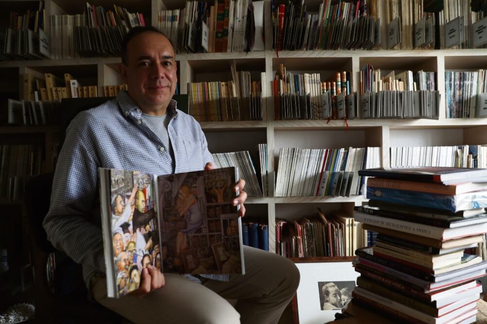Juan Coronel Rivera, nieto de Diego Rivera, muestra un catálogo donde se reproducen las obras del muralista que actualmente se encuentran bajo resguardo del INBA y que son objeto de disputa por parte del SNTE. (JUAN CARLOS REYES. EL UNIVERSAL)