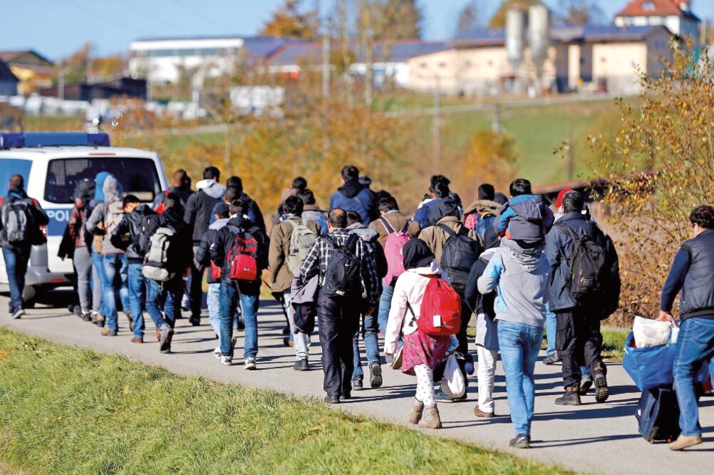 Migrantes son escoltados por la policía alemana hacia un centro de registro, tras cruzar la frontera desde Austria, en Wegscheid, cerca de Passau (MICHAEL DALDER)
