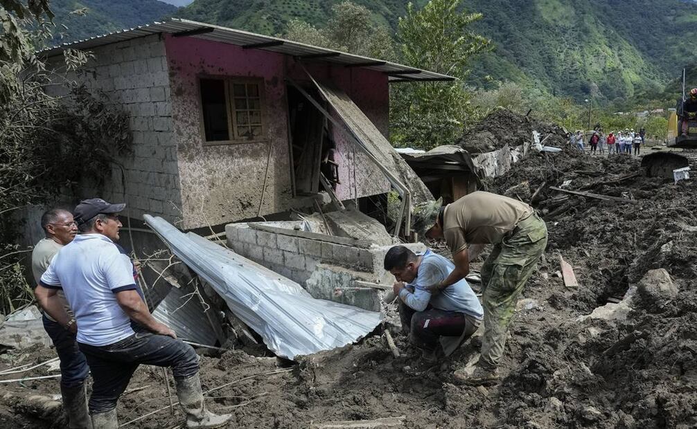 Un hombre, arrodillado, reacciona por los daños en su casa que dejaron los deslizamientos. Foto: AP