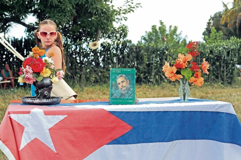 Una niña pasa junto a un pequeño altar en honor a Fidel Castro, instalado ayer a la orilla de la carretera al paso de la caravana con las cenizas del líder cubano en el camino a la ciudad de Santiago de Cuba (DARÍO LOPEZ-MILLS. AP)