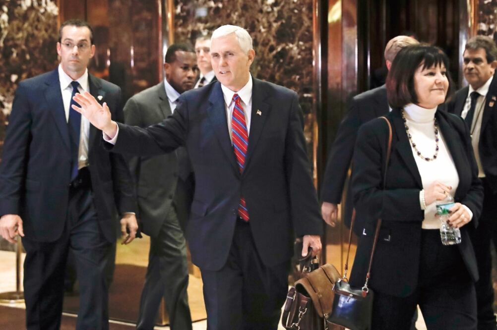 El vicepresidente electo, Mike Pence, acompañado por su esposa Karen, saluda a la prensa a su salida de la Trump Tower, ayer en Nueva York. (FOTO: CAROLYN KASTER. AP)