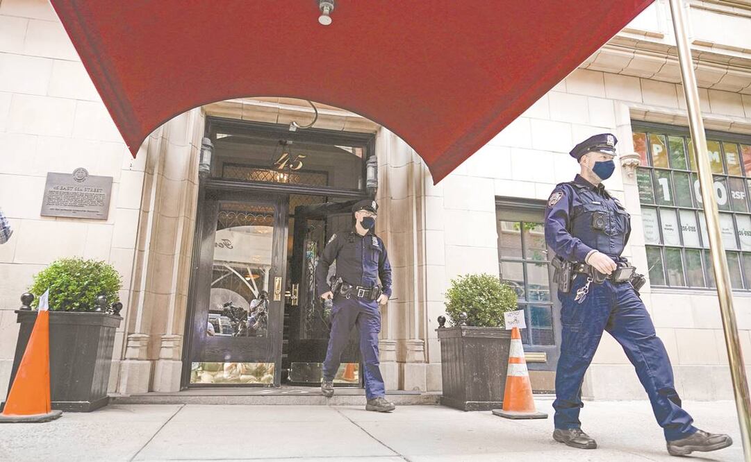 Policías de Nueva York salen del edificio donde está el departamento de Giuliani, en Manhattan, ayer. Foto: Mary Altaffer/ AP.