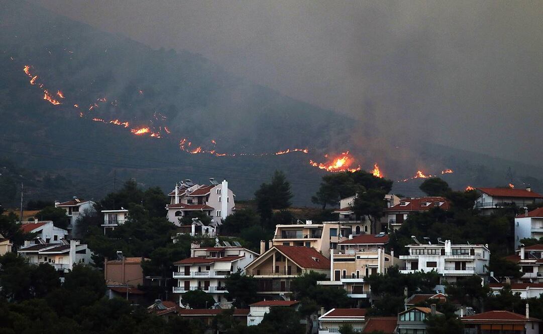Incendio acercándose a las casas en el monte Penteli, en el noreste de Grecia. Foto: EFE