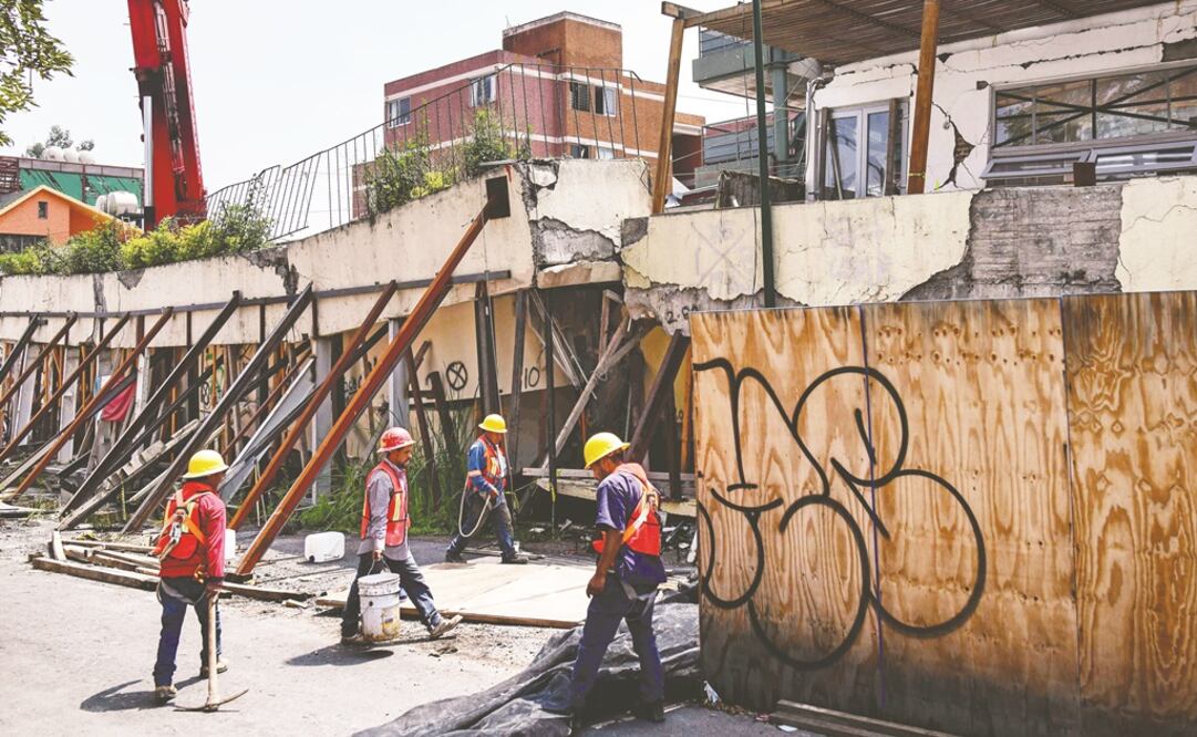 Más de 30 trabajadores y cinco grúas se dieron cita en punto de las 9:00 horas del lunes en el colegio, el cual cercaron con tablas para evitar accidentes. (RONALDO SCHEMIDT. AFP)