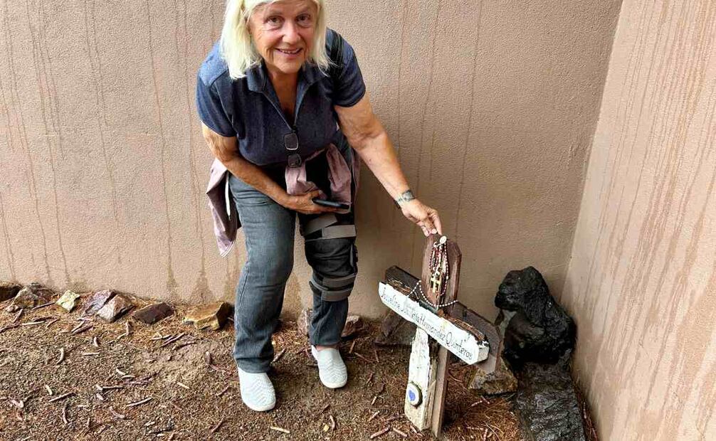 Gail Kocourek, una voluntaria del grupo humanitario Los Samaritanos, posa este lunes junto a una cruz colocada frente a la entrada de la Iglesia Presbiteriana en memoria de la menor de 15 años Josseline Jemileth Hernández Quintero, fallecida en el desierto de Arizona, en Tucson, Arizona (EU). Ciudadanos estadounidenses del grupo humanitario Los Samaritanos, que distribuyen agua y ayuda a migrantes en el desierto entre Arizona y México, relataron a EFE la persecución y arresto que enfrentaron en marzo pasado de hombres armados, encubiertos, en carros sin insignias y sin orden judicial, que resultaron ser agentes migratorios de EU. Foto: EFE