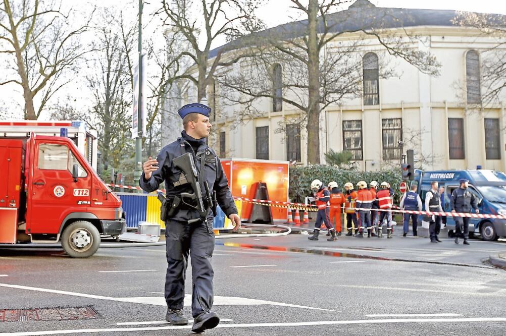 Un policía belga y bomberos trabajan afuera de la Gran Mezquita de Bruselas, donde se halló polvo blanco sospechoso que resultó ser harina (FRANCOIS LENOIR. REUTERS)