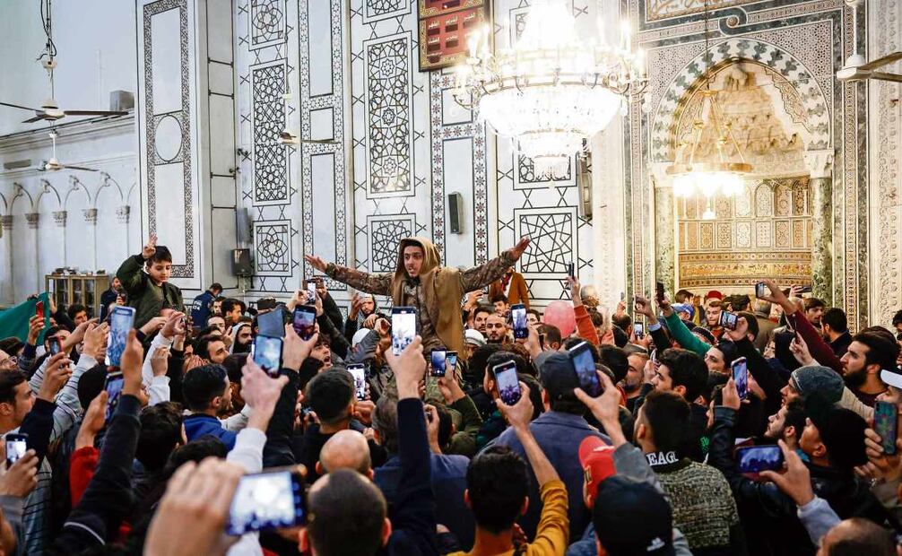 Sirios celebran dentro de la Mezquita Omeya, tras el derrocamiento del presidente Al-Assad por rebeldes de la oposición, en Damasco. Foto: Antonio Pedro Santos / EFE