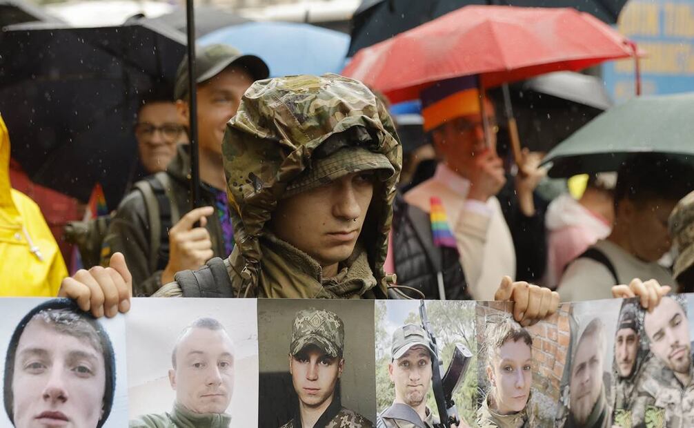 Representantes de la comunidad LGBT sostienen una pancarta que muestra fotografías de soldados LGBT muertos en acción en medio de la invasión de Rusia. Foto: EFE
