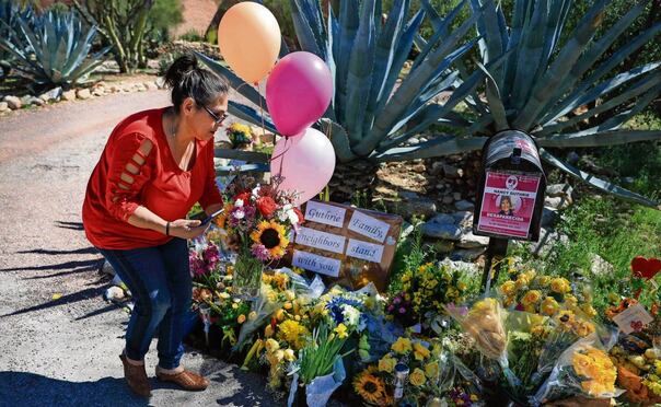 Monica Emerson coloca flores en un monumento conmemorativo instalado a la entrada de la casa de Nancy Guthrie, en Tucson, Arizona. Foto: Joe Raedle / AFP