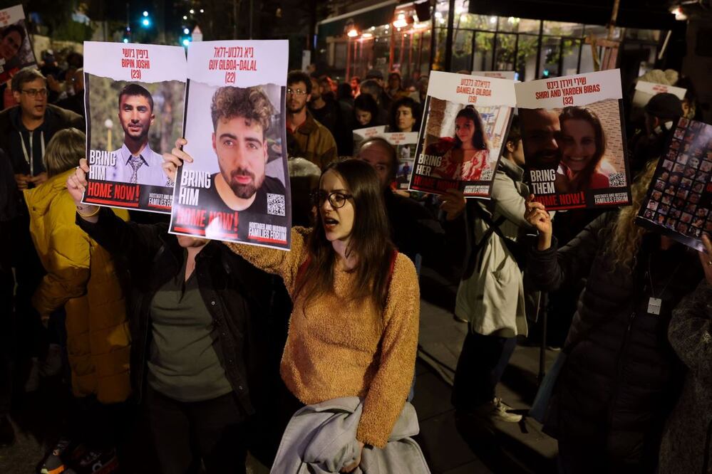 Manifestantes sostienen retratos durante una concentración organizada por familiares y simpatizantes de los rehenes israelíes retenidos en Gaza desde los atentados del 7 de octubre perpetrados por Hamas en el sur de Israel, para exigir su liberación, el 22 de enero de 2024, cerca de la residencia del primer ministro israelí en Jerusalén. FOTO: AHMAD GHARABLI. AFP