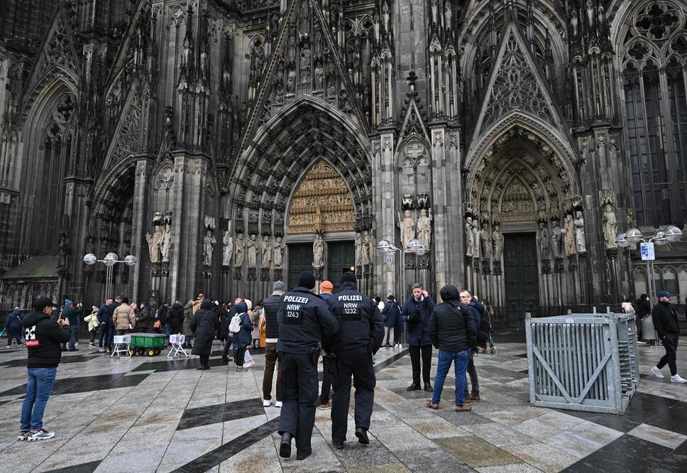 Policías vigilan la catedral de Colonia, en Alemania. La policía anunció que revisará a todas las personas que intenten ingresar, tras una "advertencia de seguridad" en las fiestas de fin de año. FOTO: AFP
