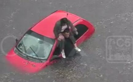 Video. Mujer se trepa a hombros de policía para salir de encharcamiento en CDMX