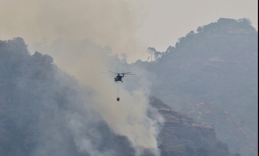 Un helicóptero de la Guardia Nacional realiza descargas de agua en la zona de las Tirolesas en Santo Domingo, Tepoztlán, el 15 de abril de 2025. Foto: Cuartoscuro.com