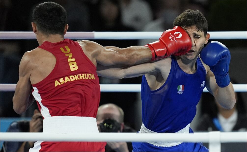 Marco Verde recibe un golpe de derecha de parte del uzbeko Asadkhuja Muydinkhujae. FOTO: AP