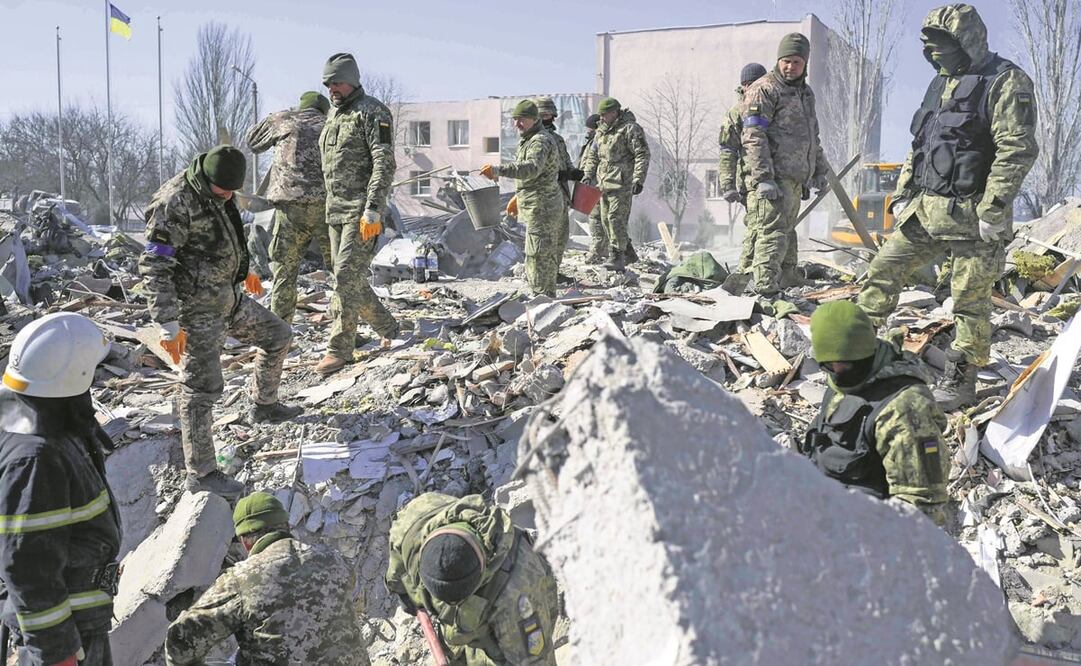 Soldados ucranianos buscan cuerpos entre los escombros en la escuela militar alcanzada por cohetes rusos, en Mykolaiv. Foto: BULENT KILIC. AFP
