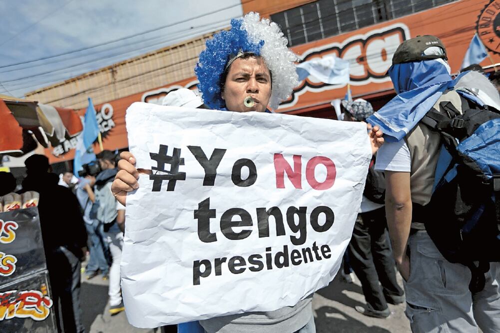 Un guatemalteco que lleva una peluca con los colores de la bandera nacional, durante la protesta de ayer contra Otto Pérez (JORGE DAN LOPEZ. REUTERS)