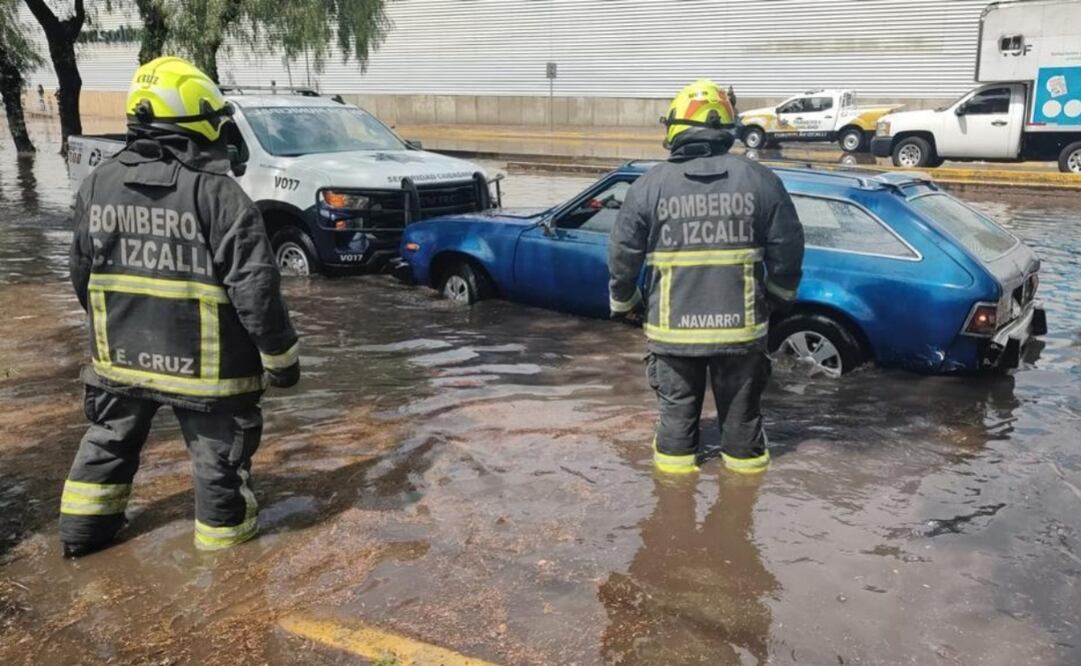 Habitantes y bomberos trabajan en la liberación de alcantarillas en la Av. López Portillo. Foto: Especial