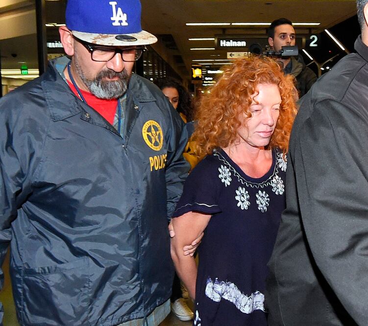 La mujer apartó la Mirada de las cámaras y fue trasladada a un auto policial camuflado en el que se marchó (AP)