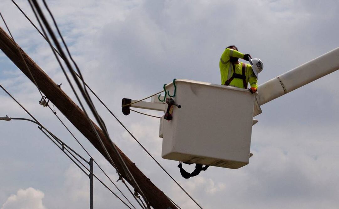 Un trabajador del equipo de asistencia exterior de CenterPoint se limpia el sudor de la frente mientras trabaja con otros para restaurar las líneas eléctricas el 11 de julio de 2024. Foto: AFP