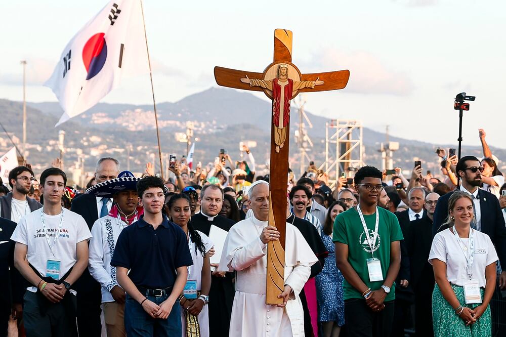 El Papa León XIV (centro) lleva una cruz a su llegada al barrio de Tor Vergata, al este de Roma, para una vigilia de oración antes de la misa dominical del Jubileo de la Juventud. Foto: EFE