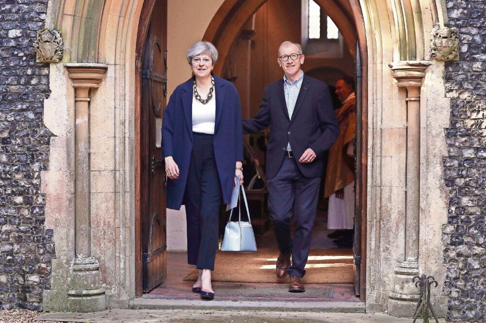La primera ministra de Reino Unido, Theresa May, y su esposo Philip acudieron ayer a la iglesia de St. Andrew, en Sonning, Berkshire (AP)