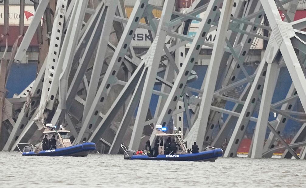 Barcos de la policía trabajan alrededor de un carguero atrapado bajo parte de la estructura del puente Francis Scott Key, en Baltimore, un día después de que el carguero chocó contra una columna del puente y causó su derrumbe. Foto: AP