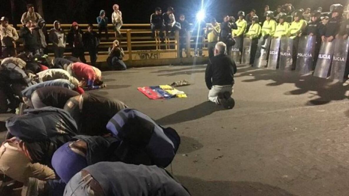 Un grupo de venezolanos se hincó ante efectivos ecuatorianos de seguridad en el puente internacional de Rumichaca, que marca uno de los puntos de la frontera entre Colombia y Ecuador, para implorar que se les deje entrar sin visa. Foto/Caraota Digital
