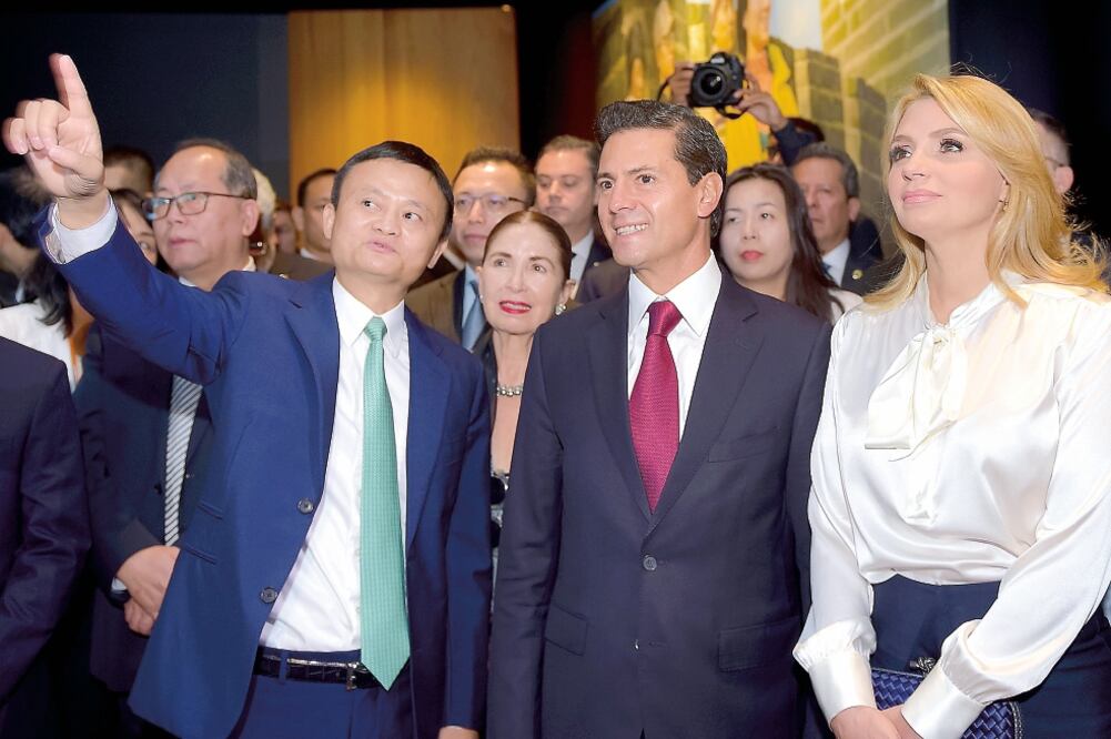 El empresario chino Jack Ma explica al presidente Enrique Peña Nieto y a su esposa Angélica Rivera el funcionamiento de la compañía comercializadora con la que se firmó un memorándum de entendimiento. (PRESIDENCIA)