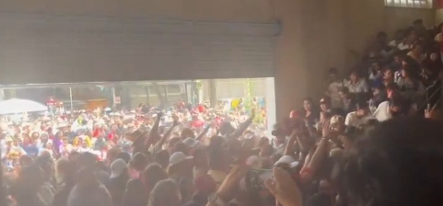 La gente generó un embudo en las escaleras para aventarse y recibir las mochilas. (Foto: captura de pantalla)