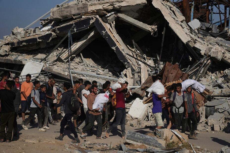 Palestinos se llevan paquetes de ayuda humanitaria distribuidos en Jan Younis, en el sur de la Franja de Gaza. FOTO: ABDEL KAREEM HANA